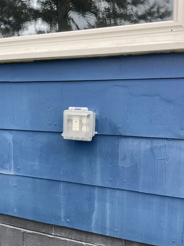 Outdoor receptacle in a weatherproof in use cover on wood siding